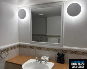 A bathroom with a mirror surrounded by soft lighting on both sides